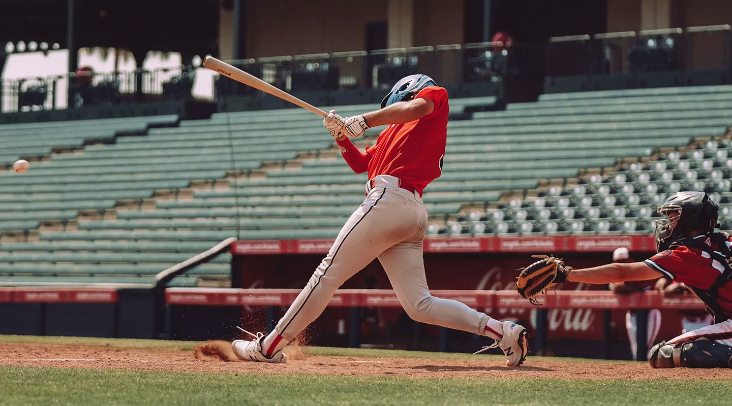 A baseball player swings at a pitch.
